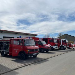 Blick auf geparkte Feuerwehrfahrzeuge vor dem Feuerwehrhaus Münchhausen