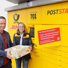 Gabriele Schulz (regionale Politikbeauftragte der DHL Group) und Bürgermeister Holger Siemon schicken das erste Paket an der neuen Poststation auf die Reise